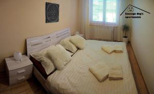 1 dormitorio con 1 cama con sábanas y almohadas blancas en Sausage dog's apartments, en Olomouc