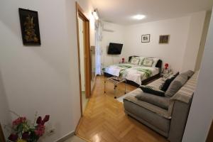 een woonkamer met een bank en een bed bij Benedetta in Pula