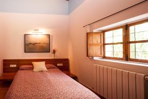 1 dormitorio con cama y ventana en can vinyeta en San Jose de sa Talaia