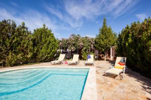 a pool with chaise lounge chairs and a swimming pool at can vinyeta in Sant Josep de Sa Talaia