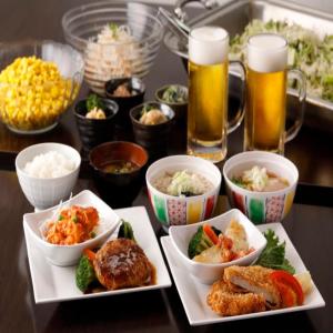 ein Tisch mit drei Teller Essen und Bier in der Unterkunft Value The Hotel Sendai Natori in Natori