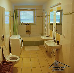 uma casa de banho com um WC, um lavatório e uma banheira em Sausage dog's apartments em Olomouc