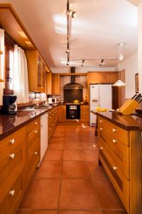 uma grande cozinha com armários de madeira e um frigorífico branco em can vinyeta em San Jose de sa Talaia