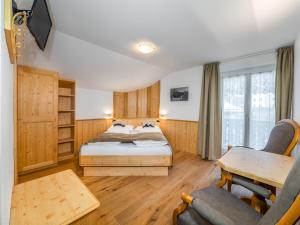 a bedroom with a bed and a desk and a chair at B&B MARINA contacless check in in Santa Cristina in Val Gardena