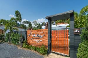 una recinzione di mattoni con cancello di fronte a un edificio di De Nathai Private Pool Villa ad Aonang Beach