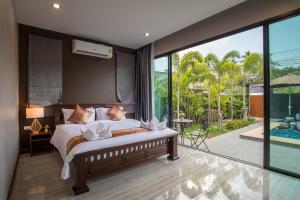アオナンビーチにあるDe Nathai Private Pool Villaの大きなベッドとバルコニーのある寝室 +124枚の写真