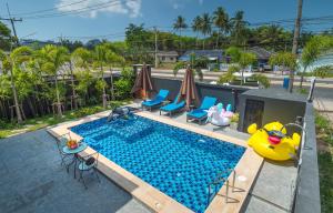an image of a swimming pool with chairs and a pool toy at De Nathai Private Pool Villa in Ao Nang Beach