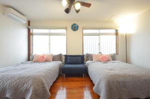 a bedroom with two beds and a couch at Sobe House in Yomitanson in Yomitan