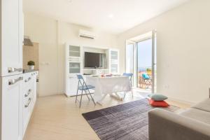 ein Wohnzimmer mit einem Tisch und eine Küche mit Aussicht in der Unterkunft Blue Apartment IUN S0079 in Cala Gonone