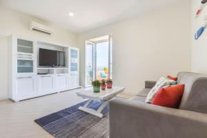 a living room with a couch and a tv and a table at Blue Apartment IUN S0079 in Cala Gonone