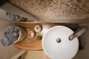 a bathroom with a white sink on a wooden counter at KAPSOTT B&B in Bisceglie