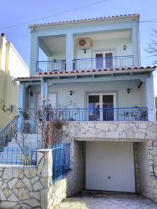 a white house with blue balconies and a garage at Studio Sun in Arta