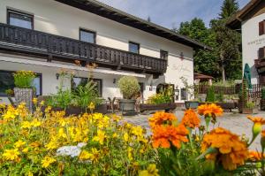 einen Garten vor einem Gebäude mit Blumen in der Unterkunft Waldhotel Bad Jungbrunn in Tristach