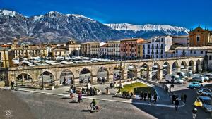 a group of people walking around a city with mountains at mela__bii in Sulmona