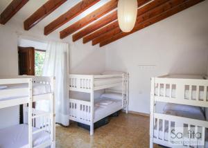 Habitación con 3 literas y techo. en Sa Fita Backpackers - Albergue Juvenil, en Esporles