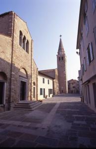 uma rua vazia com uma igreja com uma torre em Appartamento Costa Azzurra em Grado