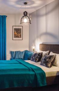 een slaapkamer met een bed met blauwe lakens en kussens bij Kaunas Old Town Apartment in Kaunas