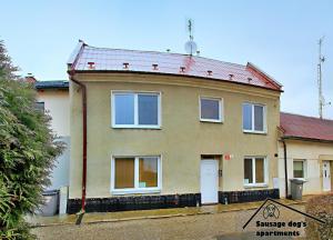 una casa con techo de estaño en una calle en Sausage dog's apartments, en Olomouc