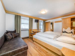 1 dormitorio con 2 camas y sofá en B&B MARINA contacless check in, en Santa Cristina Valgardena