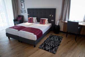 Schlafzimmer mit einem großen Bett mit einem schwarzen Kopfteil in der Unterkunft Hotel Locker & Legere in Sankt Ruprecht an der Raab