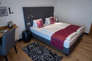 a bedroom with a large bed with a desk and a desk at Hotel Locker & Legere in Sankt Ruprecht an der Raab