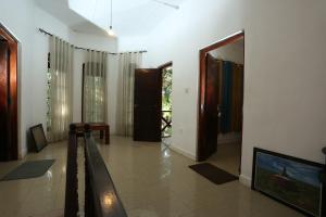 a living room with a hallway with a tv and doors at Tree Breeze Inn in Kandy
