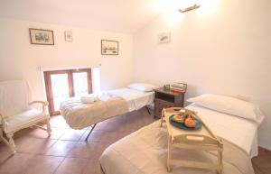 una camera con tre letti e un tavolo e una sedia di Homey Experience - Attic Sea View Apartment a La Maddalena