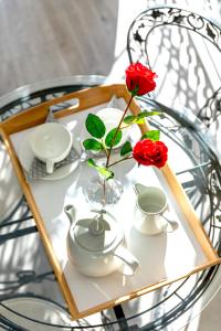 une table en verre avec un vase avec deux roses en elle dans l'établissement Athens Manor Houses, à Athènes
