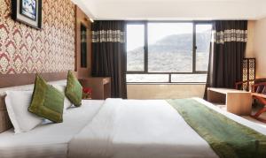 a bedroom with a large bed with a large window at Shri Vitthal Mangalam Satara in Satara +39 photos