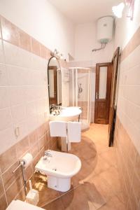 bagno con 2 lavandini e servizi igienici di Homey Experience - Attic Sea View Apartment a La Maddalena
