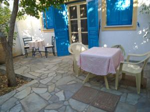 a patio with a table and chairs in front of a house at Sea Front two bedroom House in Lesvos in Tavari