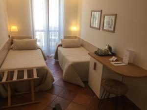 a hotel room with two beds and a desk at Da Baranin in Manarola