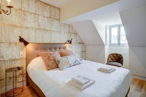a bedroom with a large bed with towels on it at Apartments Du Louvre St Honoré in Paris