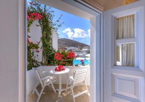 a table and chairs on a balcony with a view of the ocean at Chora Resort Hotel & Spa in Chora Folegandros