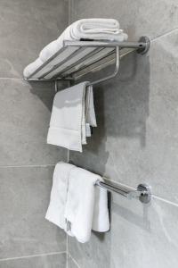 a towel rack in a bathroom with white towels at Cresta Jwaneng in Jwaneng