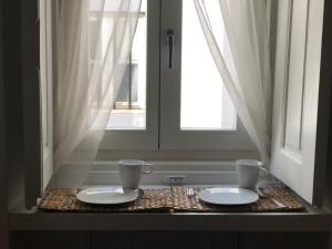a table with two white plates and two windows at Casa da Travessa in Évora +76 photos
