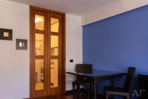 a room with a door and a table with a laptop at Corso San Gottardo - Darsena Flat in Milan