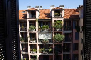 an apartment building with plants on the balconies at Corso San Gottardo - Darsena Flat in Milan