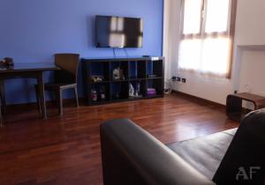 a living room with a couch and a tv on a blue wall at Corso San Gottardo - Darsena Flat in Milan