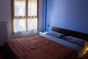 a blue bedroom with a bed with a red blanket at Corso San Gottardo - Darsena Flat in Milan