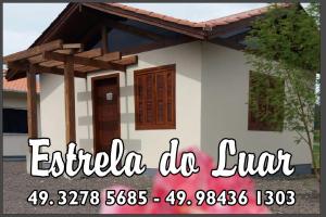 una casa pequeña se muestra con las palabras extra la luz en Pousada Estrela Do Luar, en Urubici