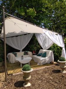 a white tent with a table and chairs under it at Le Clos de la Vigneronne in Messas