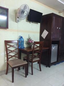 a dining room table with two chairs and a fan at Kien Nhi Tam Motel in Vung Tau
