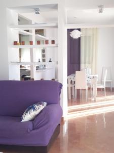 sala de estar con sofá púrpura y comedor en ATICO-PLAZA, en Algodonales