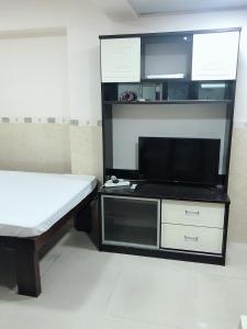 1 dormitorio con 1 cama y TV de pantalla plana en Hung Fai Guest House en Hong Kong