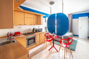 uma cozinha com uma mesa vermelha e cadeiras em Garden Apartments em Praga