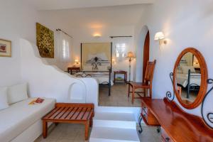 a living room with a couch and a mirror at Chora Resort Hotel & Spa in Chora Folegandros