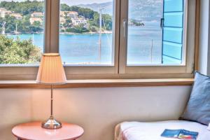 a lamp sitting on a table in front of a window at ECO Aparthotel The Dreamers's Club in Lumbarda