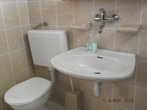 a bathroom with a white toilet and a sink at Apartman Katarina in Beli Manastir