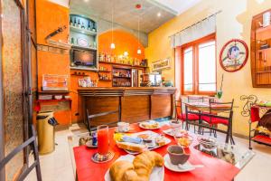 a kitchen with orange walls and a table with food on it at Albergo Della Corte in Benevento